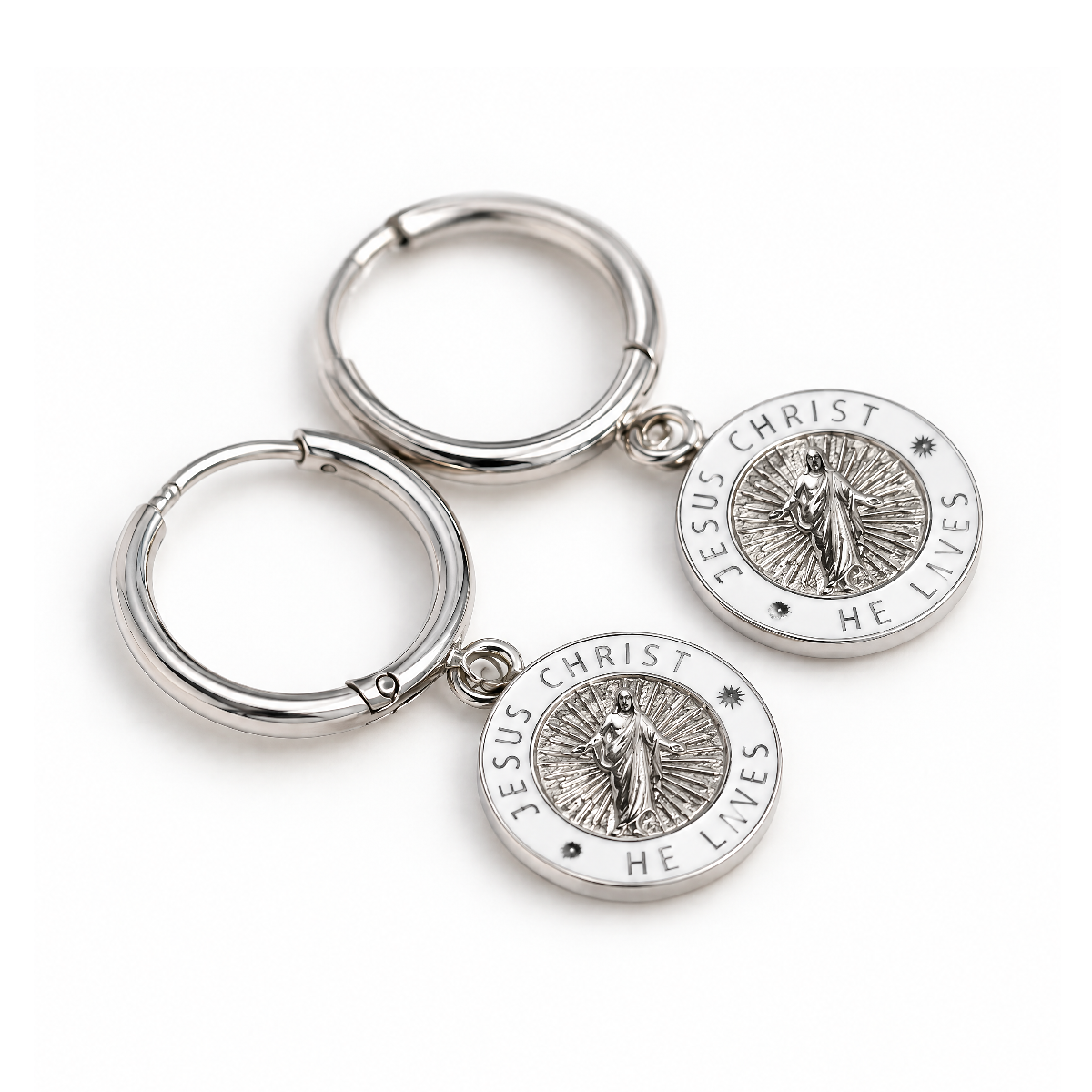 Silver and white Jesus Christ He Lives hoop earrings lying flat